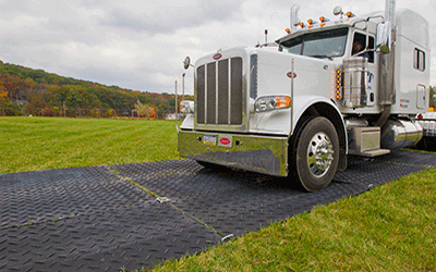 Home Heavy-duty HDPE ground protection mats supporting semi truck on grass field temporary access roadaccess