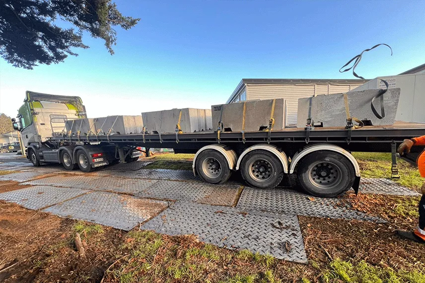 Truck driving on HDPE temporary road mats for wedding event ground protection on soft muddy terrain