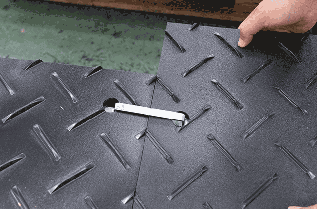 Products HDPE ground protection mats demonstrating secure interlocking connection system with tool