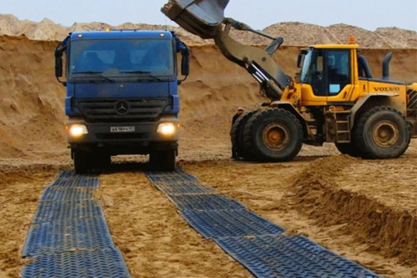 Heavy truck operating on HDPE temporary road mats for unstable ground access in civil engineering projects